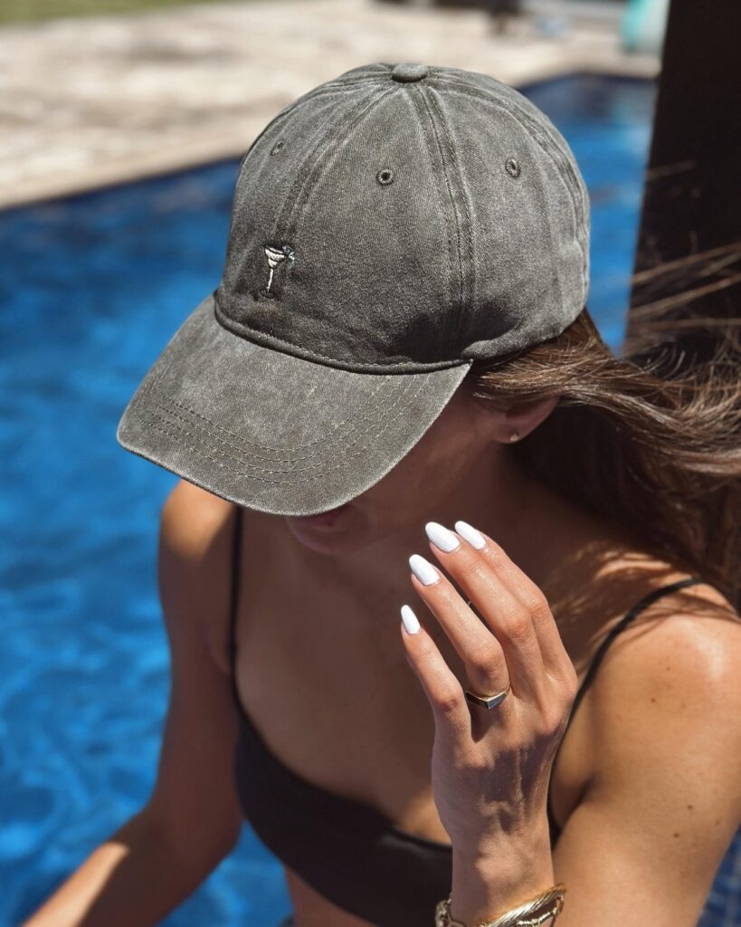 Chica con la gorra Martini de agua sal junto a la piscina